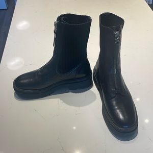 Black boots, zip-up, hugs ankle. Barely warn.